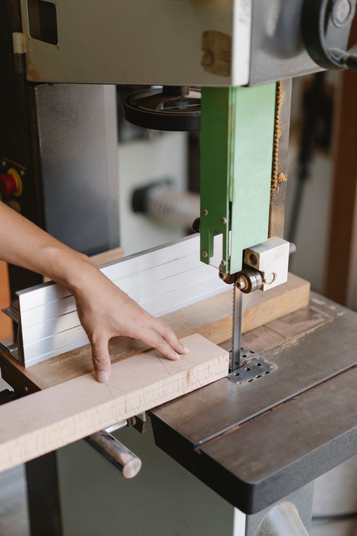 Mastering the First Impression: Your intriguing post title goes here Crop unrecognizable woodworker sawing wooden plank with band saw with sharp blade in daytime